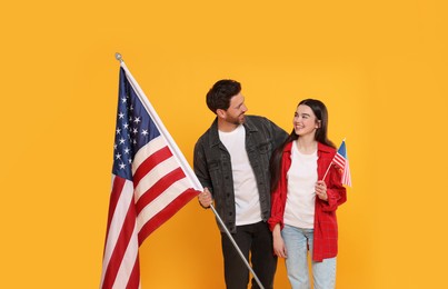 Photo of 4th of July - Independence Day of USA. Happy man and his daughter with American flag on yellow background