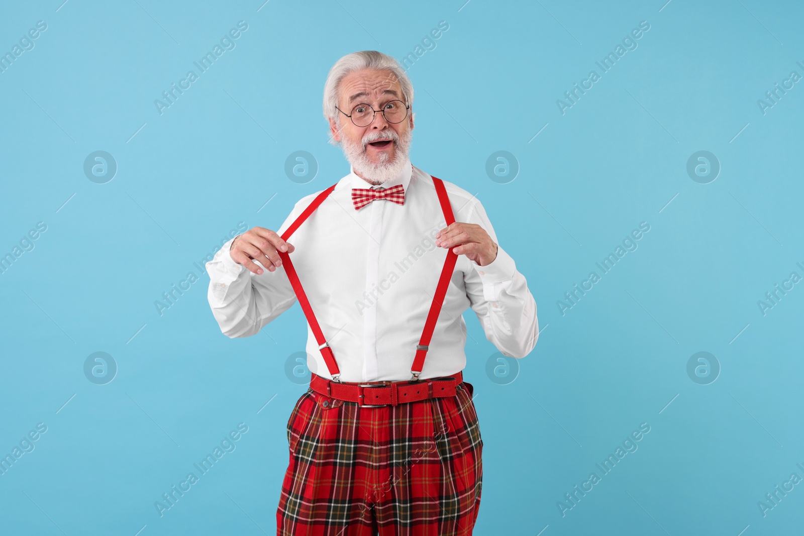 Photo of Portrait of stylish grandpa with glasses and bowtie on light blue background