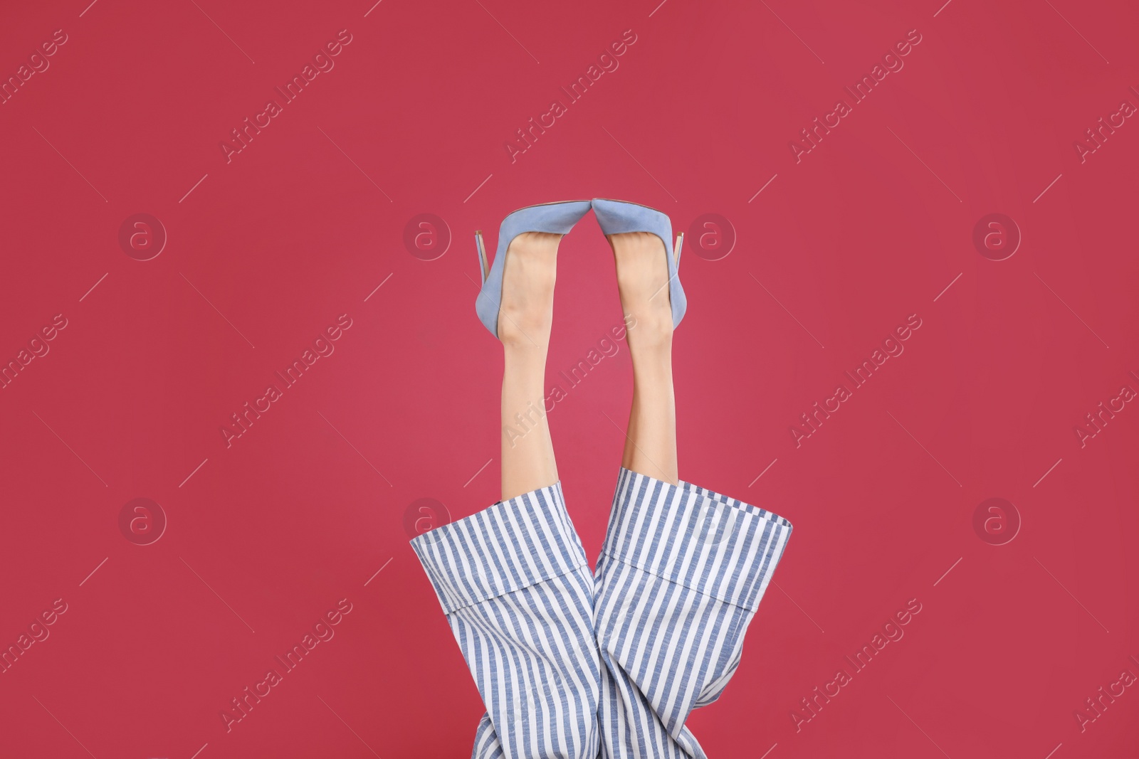 Photo of Woman in elegant shoes on crimson background