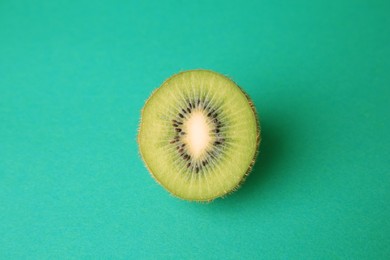 Photo of Cut fresh ripe kiwi on green background, top view