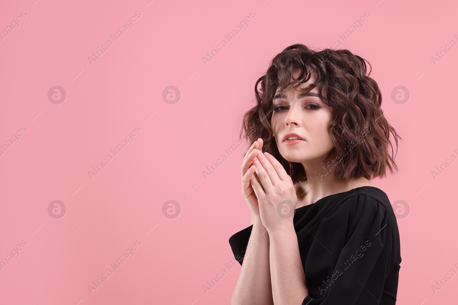 Photo of Portrait of beautiful young woman with wavy hairstyle on pink background. Space for text