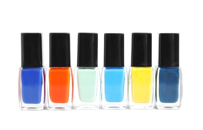 Photo of Bottles of nail polish on white background