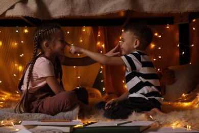 Photo of Children playing in play tent at home