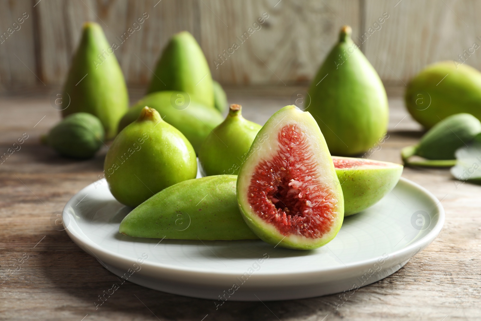 Photo of Plate with fresh ripe figs on table. Tropical fruit