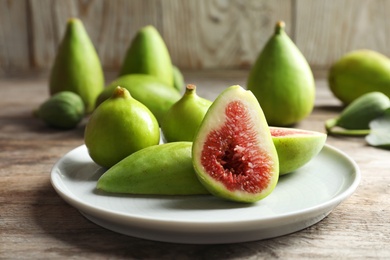 Photo of Plate with fresh ripe figs on table. Tropical fruit