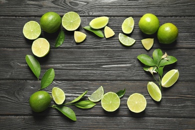 Frame of fresh ripe limes on wooden background, top view