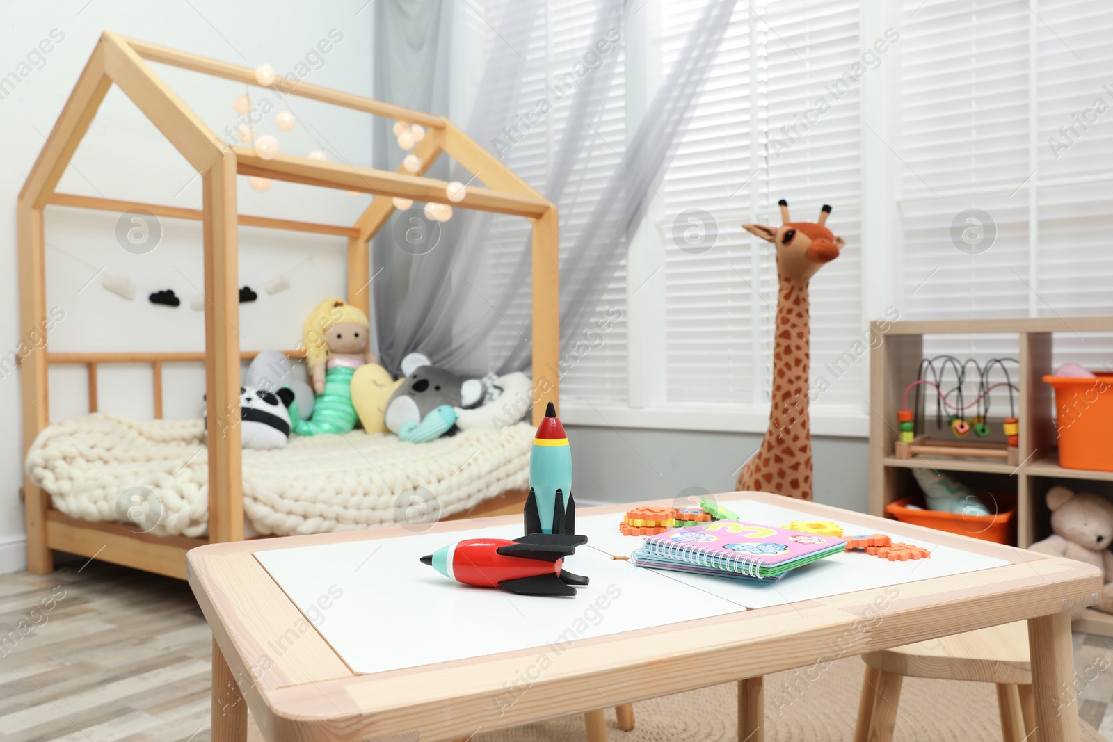 Photo of Cute child's room interior with toys and wooden furniture