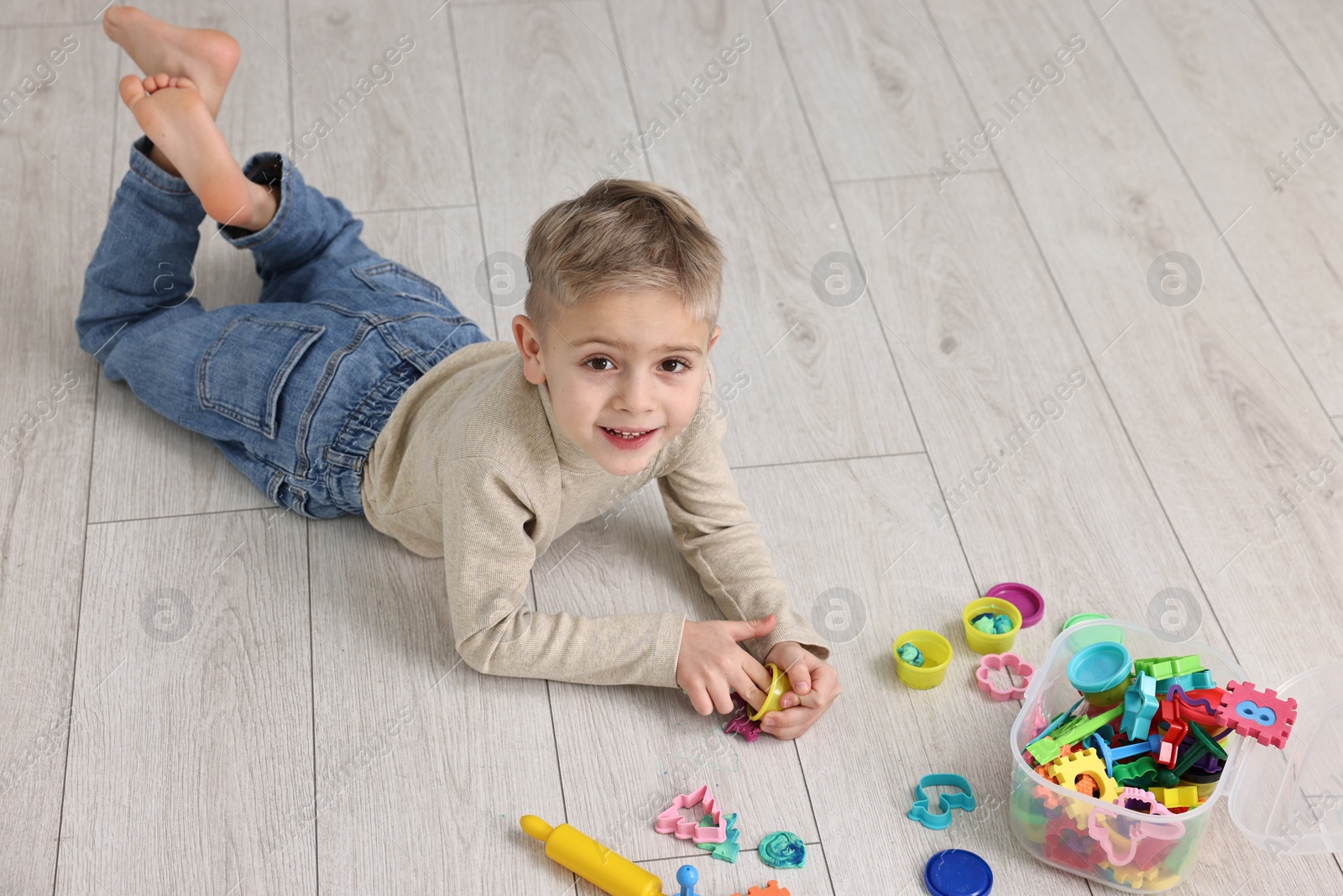 Photo of Cute little boy playing on warm floor indoors, space for text. Heating system