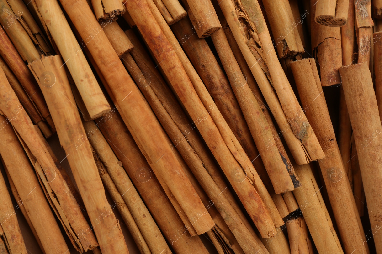 Photo of Aromatic cinnamon sticks as background, top view