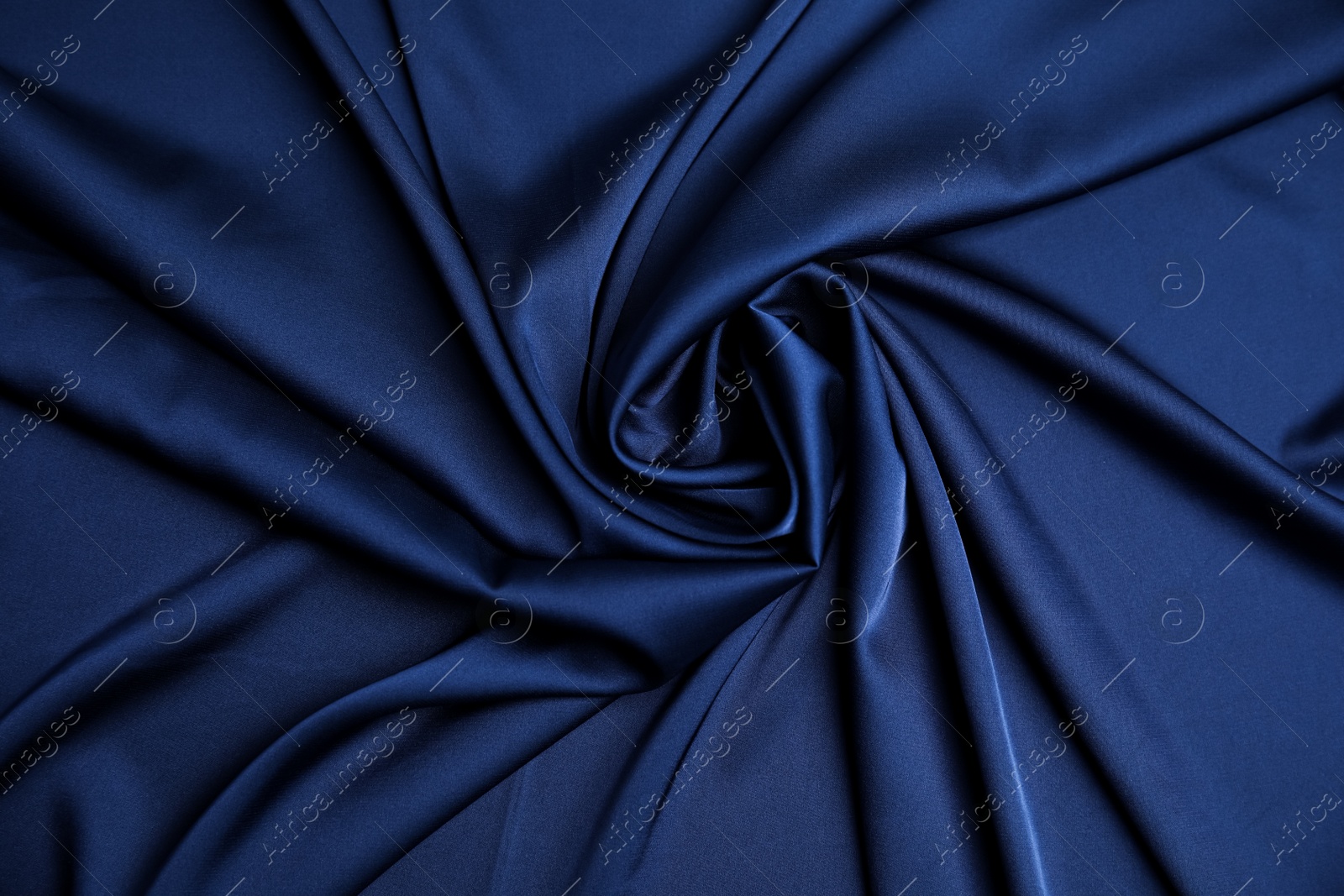 Photo of Crumpled dark blue silk fabric as background, top view