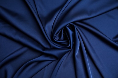 Photo of Crumpled dark blue silk fabric as background, top view