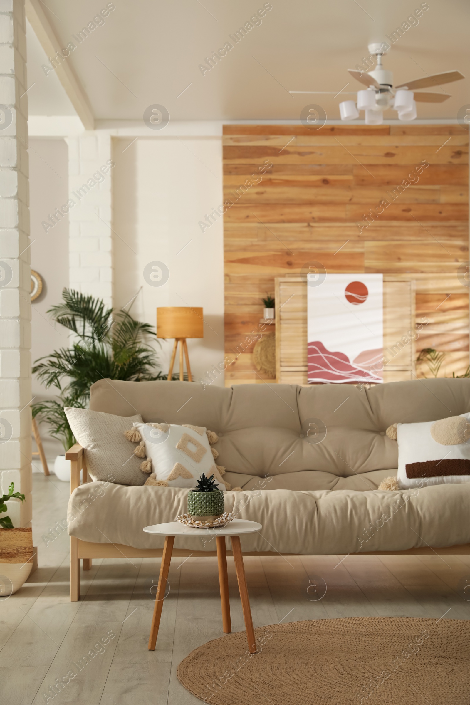 Photo of Light room interior with stylish wooden sofa and table. Idea for design