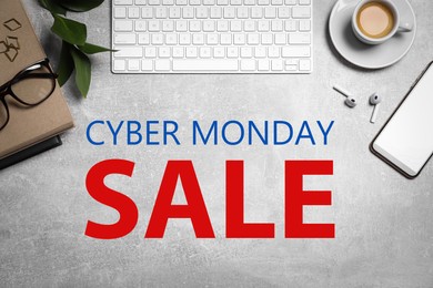 Cyber Monday Sale. Flat lay composition with computer keyboard and smartphone on grey table 