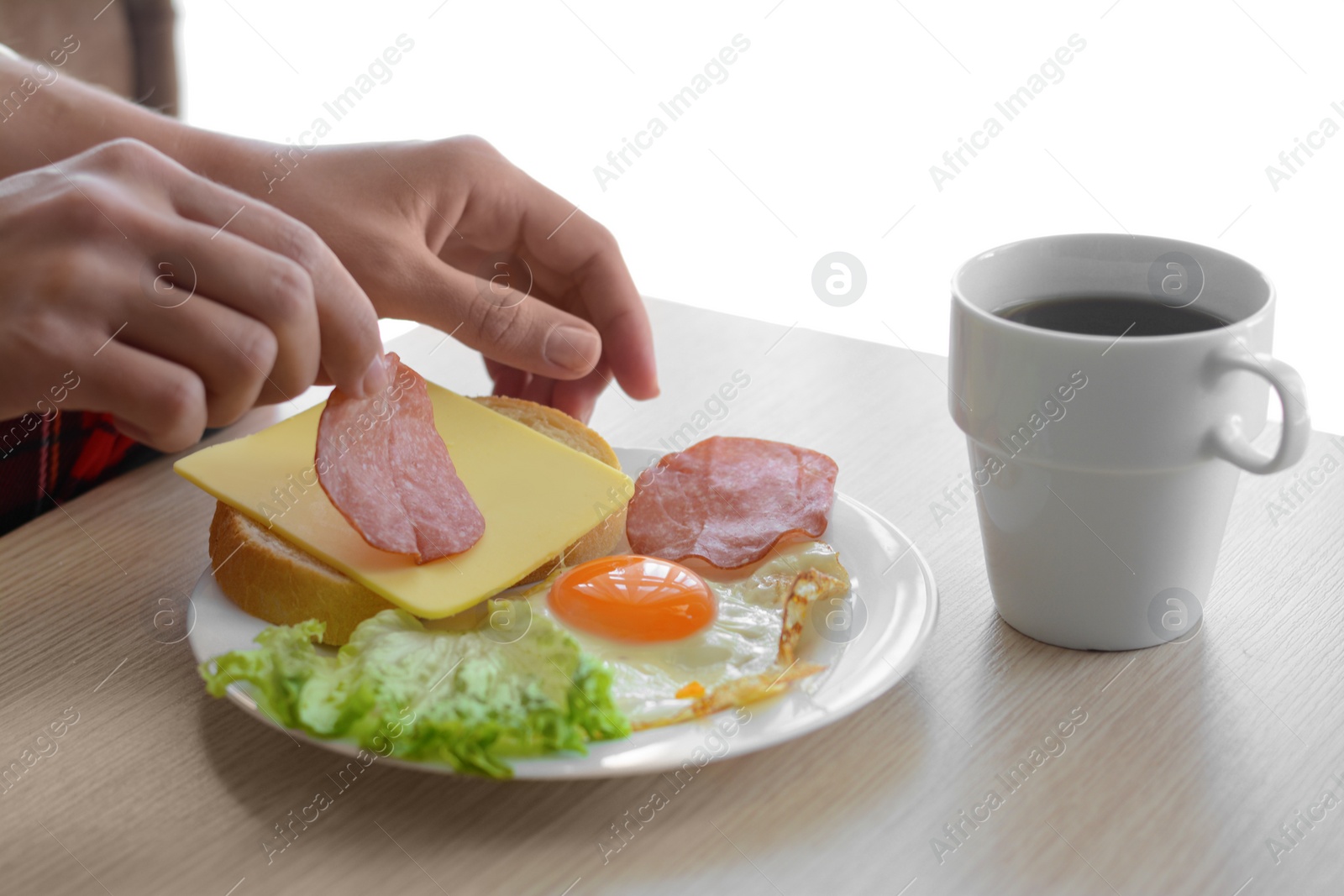 Photo of Woman preparing tasty nutritious breakfast at wooden table against white background, closeup. Good morning