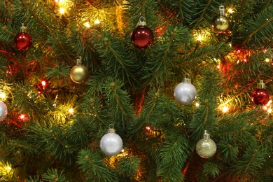 Photo of Glowing bright fairy lights and beautiful baubles on Christmas tree