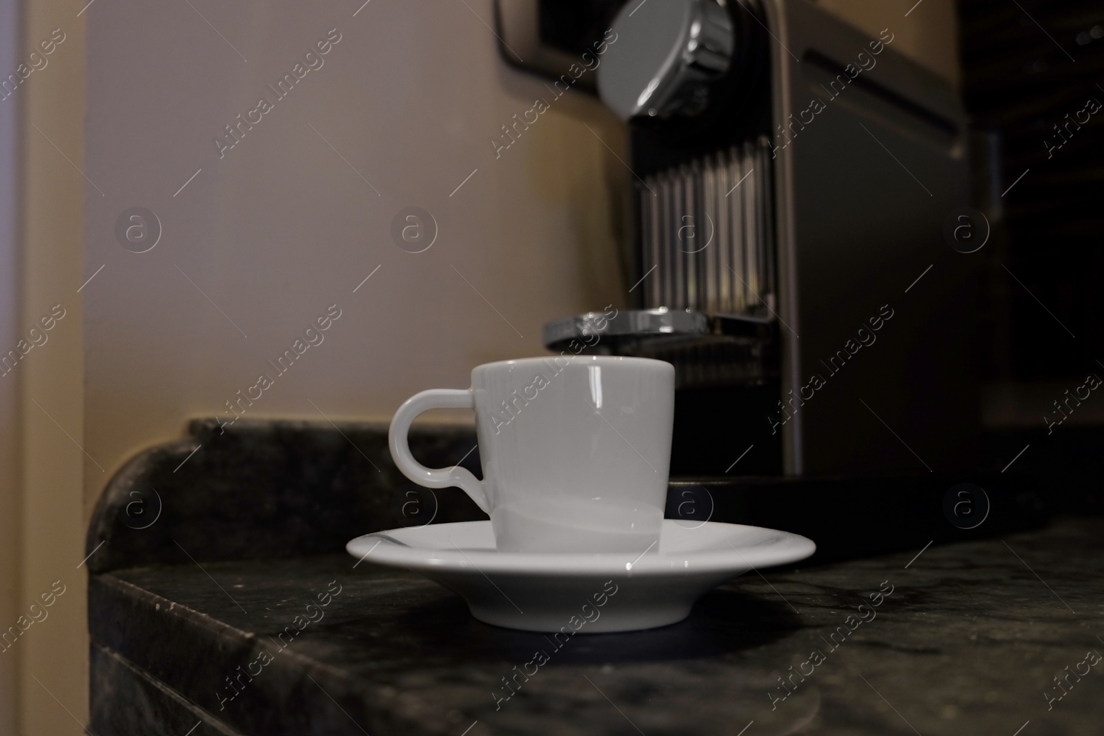 Photo of White cup near coffee machine on table