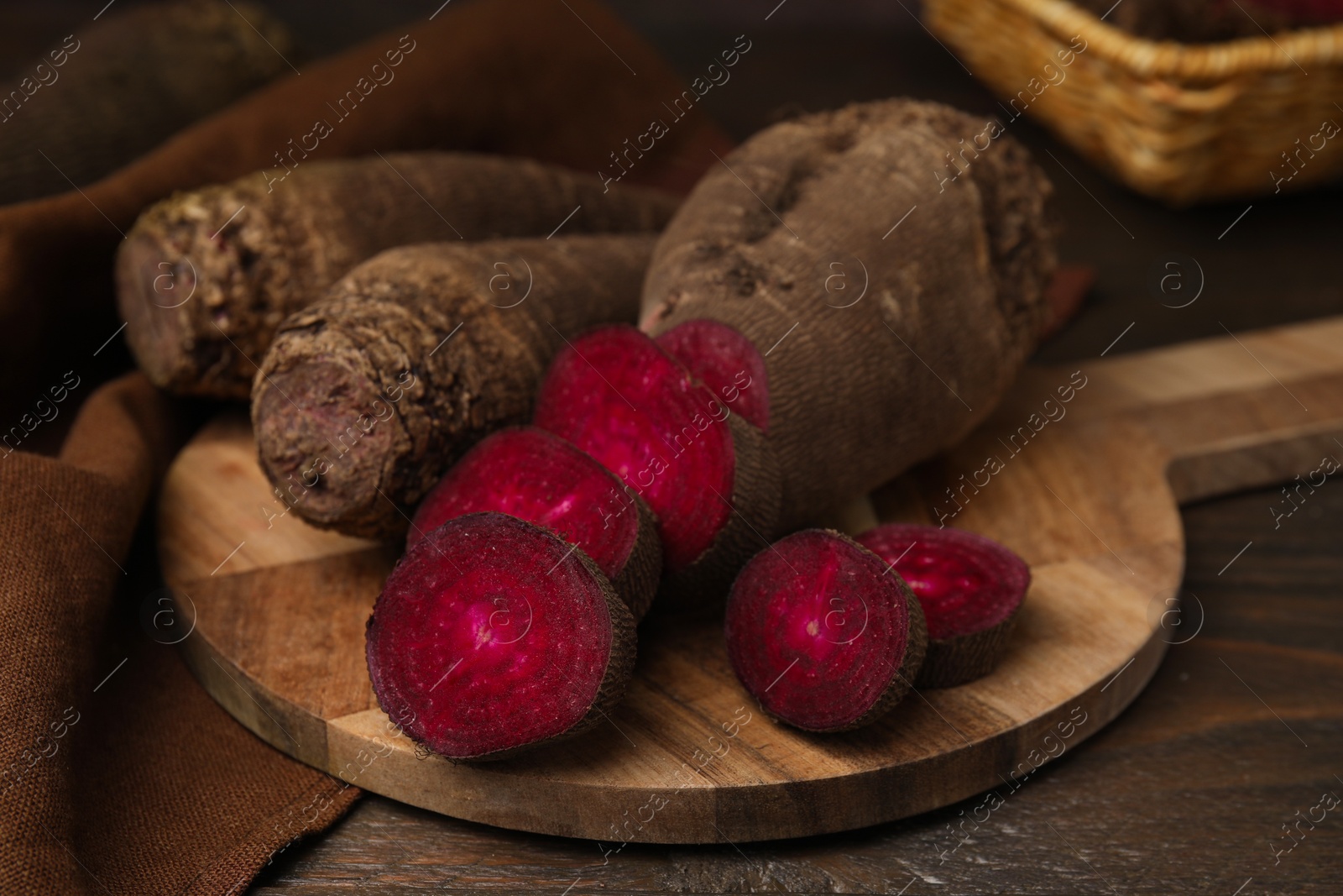 Photo of Whole and cut red beets on table, closeup