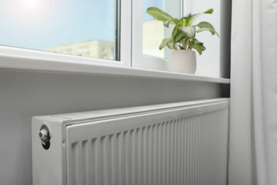 Photo of Modern radiator under window at home. Central heating system