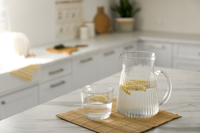 Photo of Fresh lemonade on white marble table in kitchen