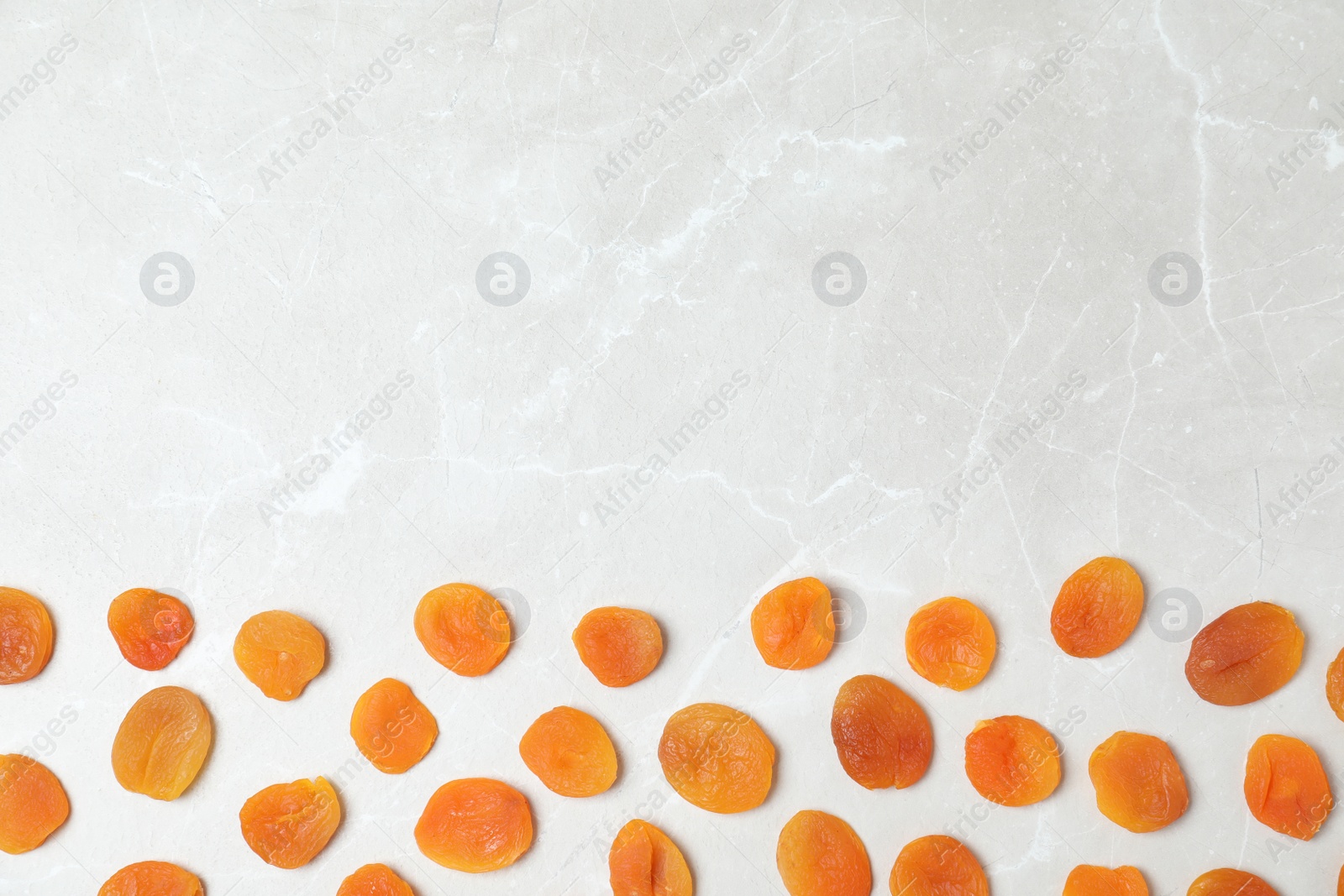 Photo of Flat lay composition with apricots on grey background, space for text. Dried fruit as healthy food