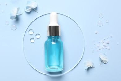 Photo of Bottle of cosmetic serum, flowers and sea salt on light blue background, flat lay
