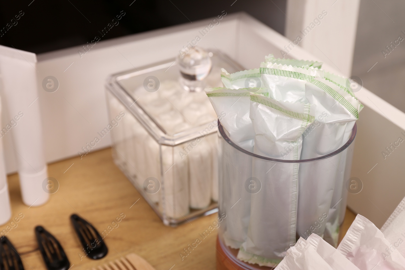 Photo of Open cabinet drawer with tampons and feminine hygiene products, closeup