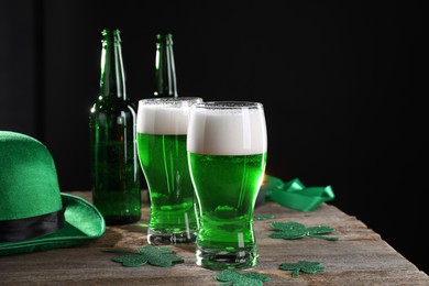 St. Patrick's day party. Green beer, decorative clover leaves and leprechaun hat on wooden table. Space for text