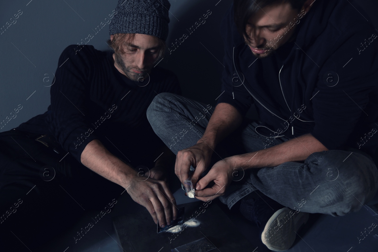 Photo of Young addicted men taking drugs on grey background