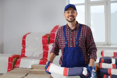 Photo of Construction worker with new building materials in room prepared for renovation