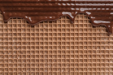 Photo of Hot dark chocolate on wafer, closeup. Crispy food