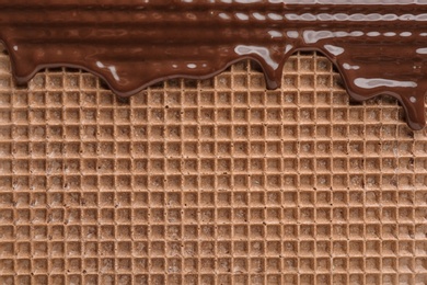 Hot dark chocolate on wafer, closeup. Crispy food