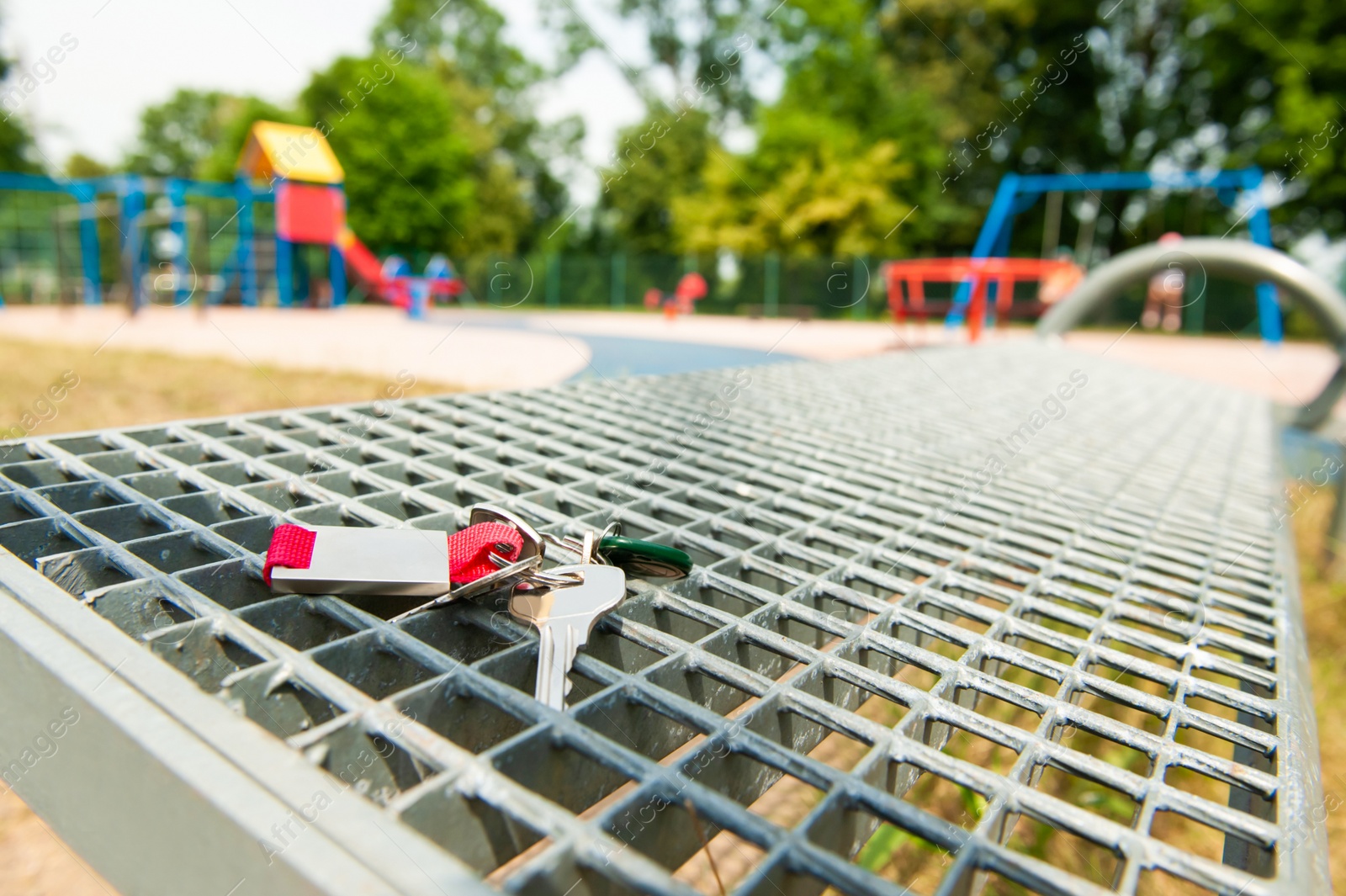 Photo of Keys forgotten on metal bench outdoors. Lost and found