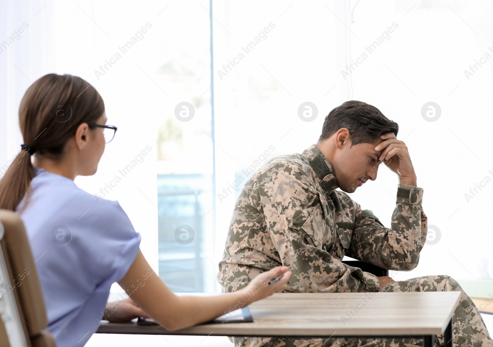 Photo of Psychotherapist working with male military officer in office