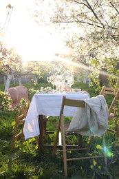 Stylish table setting with beautiful spring flowers in garden