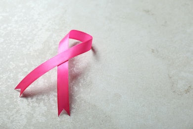 Photo of Pink ribbon and space for text on gray background. Breast cancer awareness concept