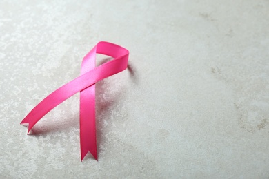 Pink ribbon and space for text on gray background. Breast cancer awareness concept