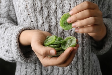 Woman holding handful of tasty kiwi, closeup. Dried fruit as healthy food