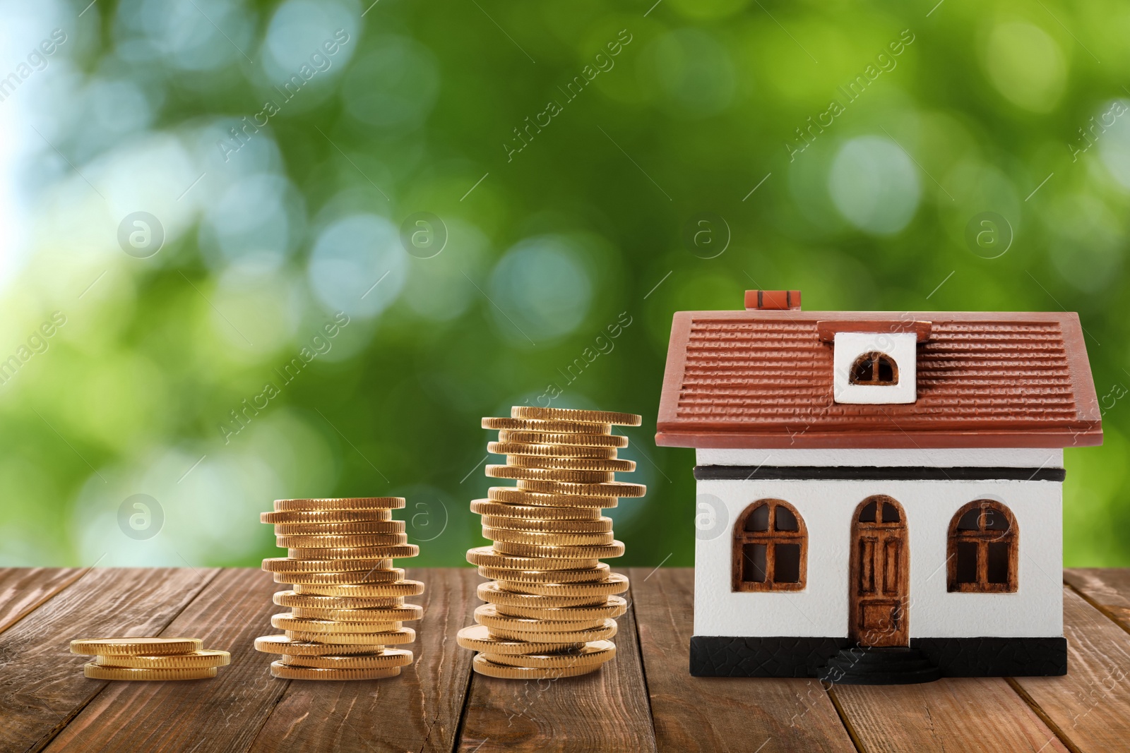 Image of Real estate investing. House model and coins on wooden table