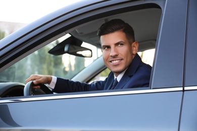 Photo of Handsome man in his modern car, view from outside