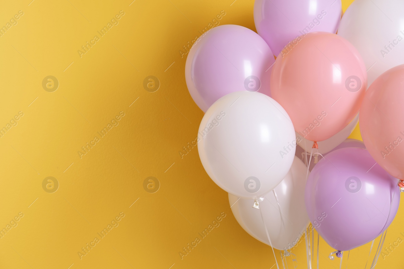 Photo of Different helium party balloons on color background. Space for text