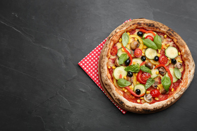 Delicious hot vegetable pizza on black table, top view. Space for text
