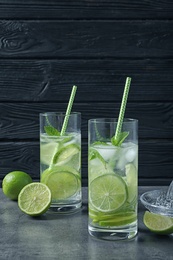 Photo of Glasses of natural lemonade with lime on table