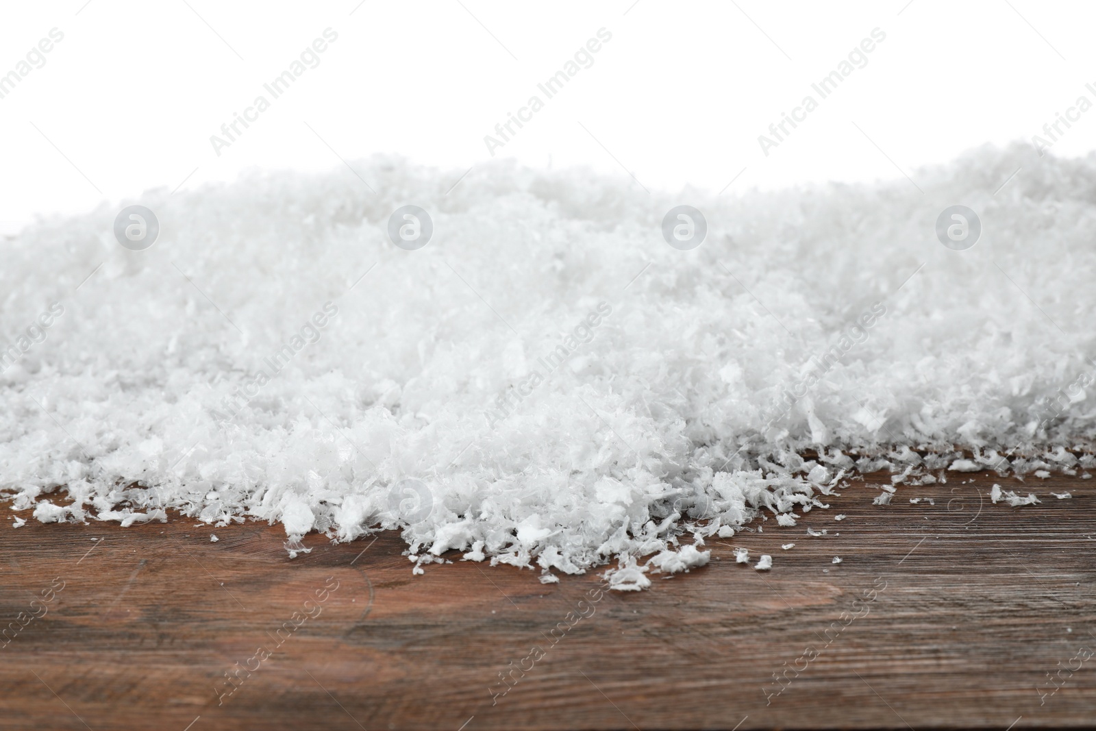 Photo of Heap of snow on wooden surface against white background. Christmas season