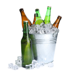 Photo of Metal bucket with bottles of beer and ice cubes isolated on white