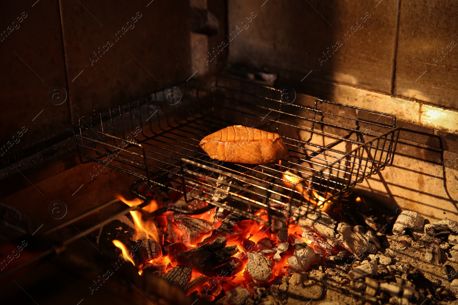 Photo of Grilling basket with tuna in oven, closeup