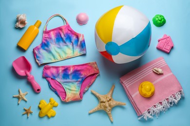 Photo of Flat lay composition with beach ball and sand toys on light blue background