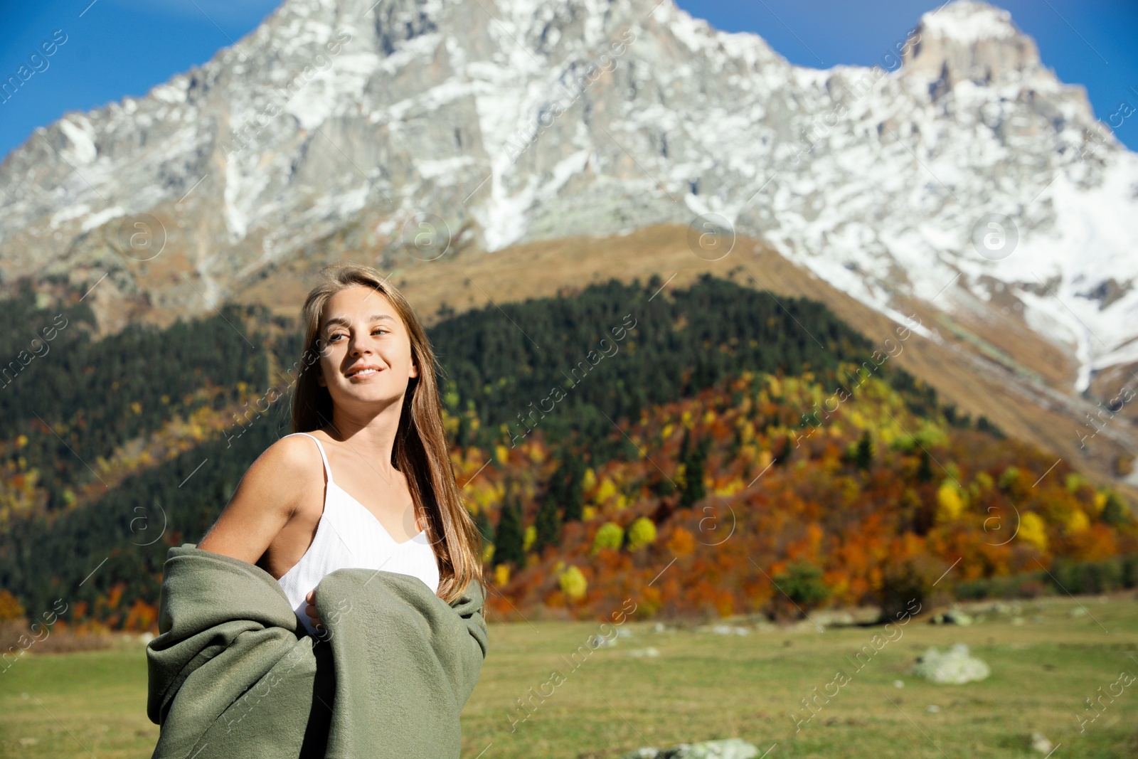 Photo of Young woman walking in beautiful mountains on sunny day. Space for text