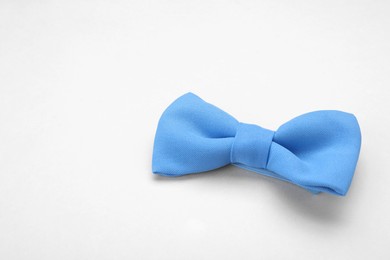 Photo of Stylish light blue bow tie on white background. Space for text