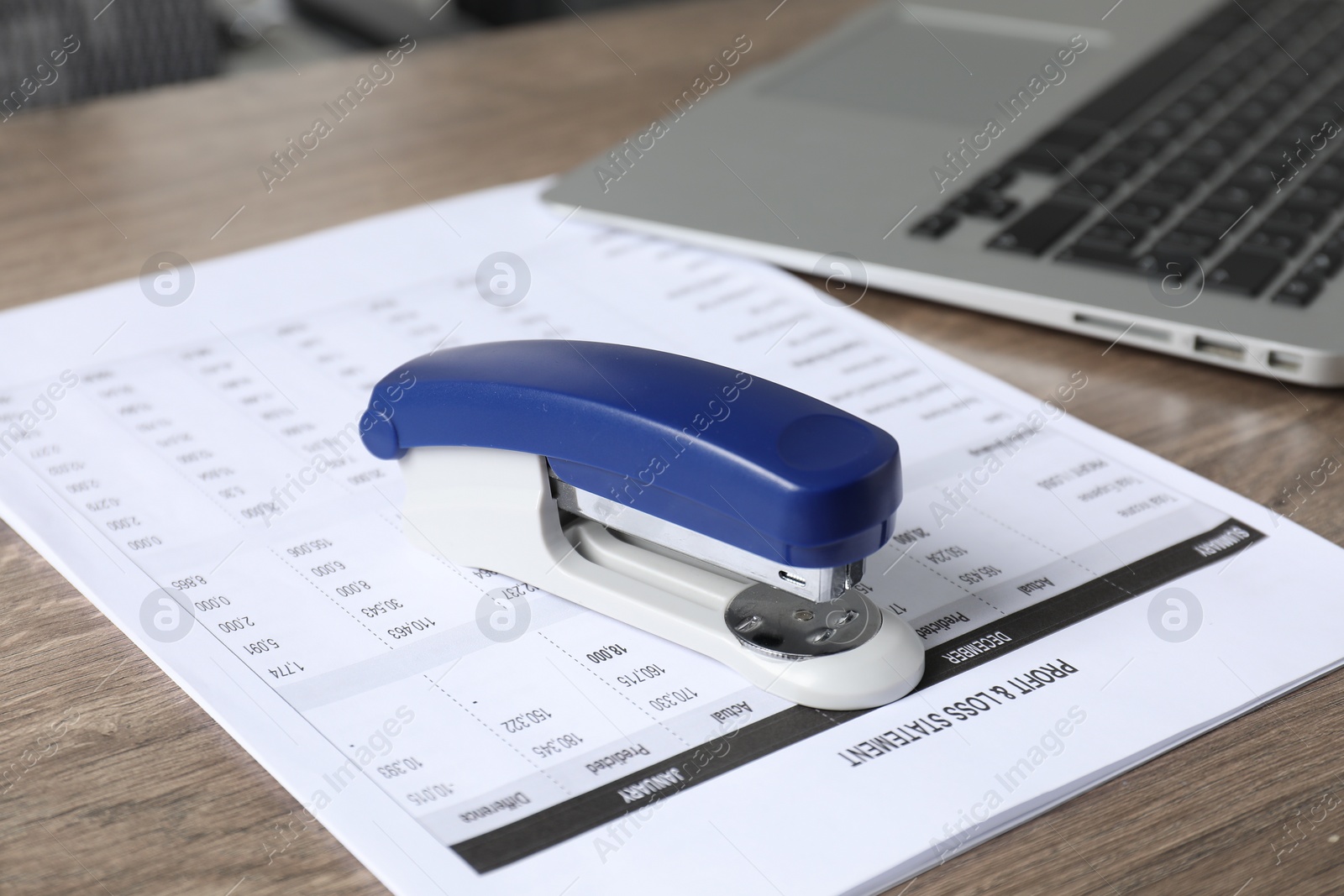 Photo of Bright stapler and document on wooden table