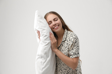 Photo of Beautiful woman with pillow on light grey background. Bedtime